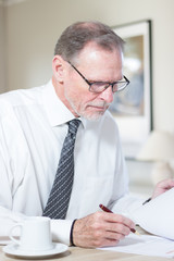  Mature businessman with glasses signing a document