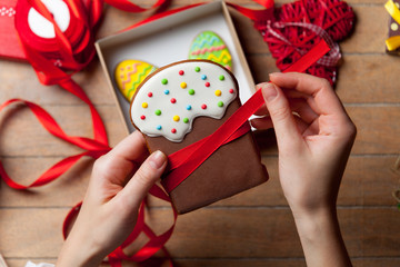 Naklejka premium Female hands are holding Easter cookie