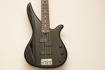 Fototapeta na wymiar black bass electric guitar hanging on the wall