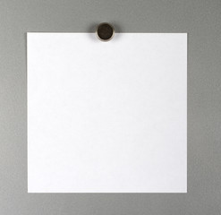 Leerer weißer Zettel an einer Metallwand mit einem Magneten befestigt