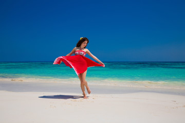 Obraz na płótnie Canvas Beautiful happy woman dancing enjoying on exotic beach in summer