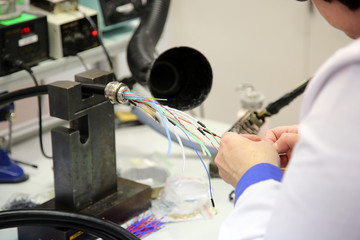 factory worker assembles the cable connections