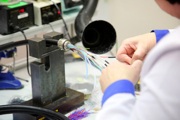 factory worker assembles the cable connections