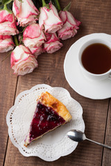 bouquet of roses and cheesecake on a wooden table