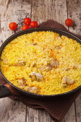 chicken pilaf in a frying pan on wood table