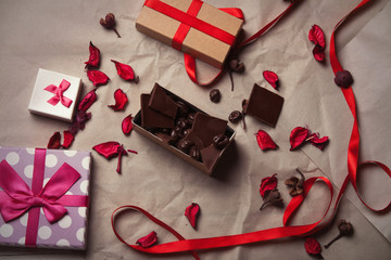 box filled with chocolate, dried flower petals and gifts lying o