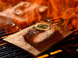 Photo sur Plexiglas Grill / Barbecue grillng salmon fillets on cedar planks with lemon and dill garnish