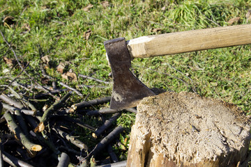 Old ax stuck in a wooden log