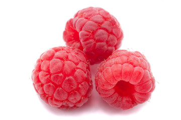 Three fresh raspberry isolated over white background. Close up macro shot.