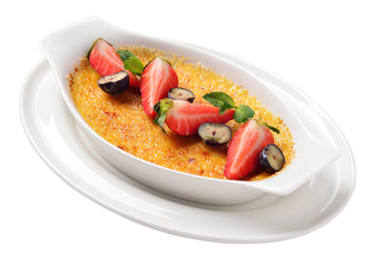 white dish with a cream brulee with raspberries, blueberries, ga