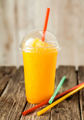 Orange Frozen Slushie in Plastic Cup with Straw