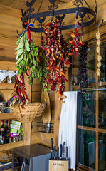 Fototapeta na wymiar pepper, prunes - dried vegetables, fruits and herbs on the background of wooden kitchen