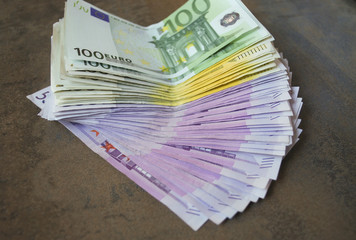 Cash Euro banknotes spread out on the table.