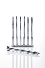 Hexagonal threaded steel bolts or screws used in carpentry. Objects on white background in line.
