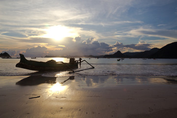 Fototapeta na wymiar Fischerboot am Strand im Sonnenuntergang auf Lombok in Indonesien
