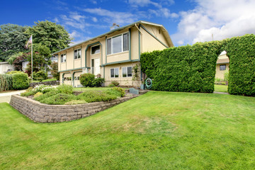 Large American home with grass front yard, and garden area.