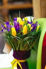 Bouquet violet irises and yellow tulips in paper wrapper