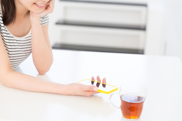 部屋でスマホを見る女性　手元