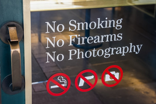 No Smoking, No Firearms, No Photography sign at the door  entrance