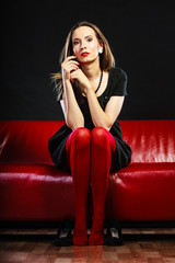 Fashion woman in red pantyhose on couch