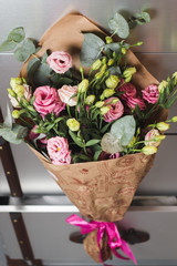 Bouquet of pink and yellow roses in paper wrapping
