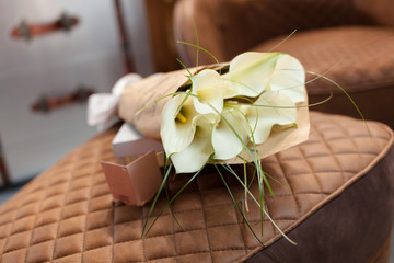 Bouquet of white callas in a paper wrapper in interior