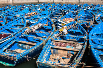 Fototapeta na wymiar ESSAOUIRA, MOROCCO - MAY 4, 2013: blue fishing boats in the port