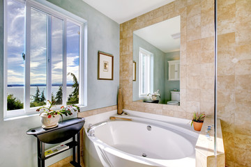Oval tub with large mirror in luxury bathroom.