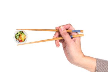Woman hand holding fresh vegetarian maki sushi roll with wooden