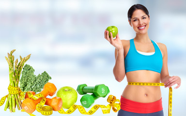 Woman measuring her waist size over blue background.