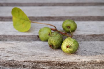 Branch of fresh baby kiwi berries on a wooden table