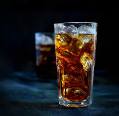 ice tea in a glass with ice against a dark background