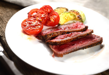 slices of steak with tomato and green sauce