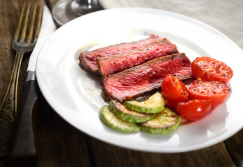 slices of steak with tomato and green sauce