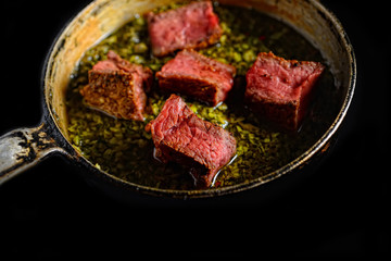 a piece of steak in green sauce