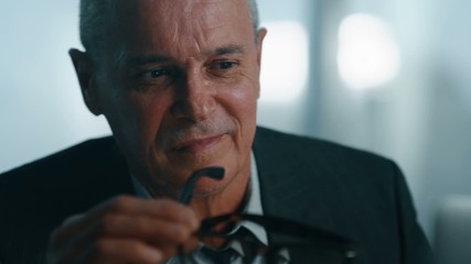 Old businessman leaned back in his office chair, he smile and daydreaming