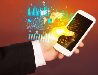 Hand holding smartphone with business diagrams