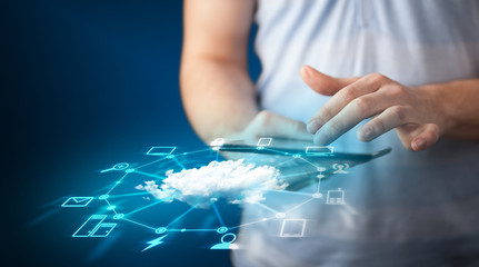 Close up of hand holding tablet with cloud network technology