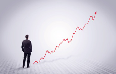 Standing businessman with red graph arrow