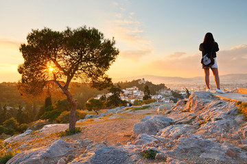 Girl photographing Thissio dominated by the National Observatory from Areopagus hill.