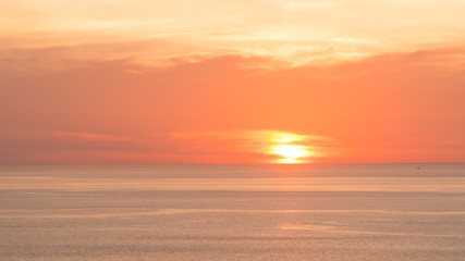 Blur beautiful soft orange sky above the sea. Sunset in background. Abstract orange sky. Dramatic golden sky at the sunset background.