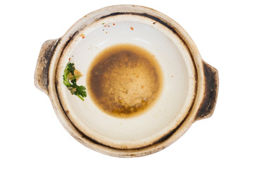 Empty white clay pot dirty with greasy and some vegetables after meal isolated on white background. Clay pot can be versatile.;