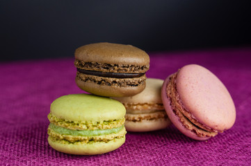 Stack of macaroons on pink jute tablecloth black background
