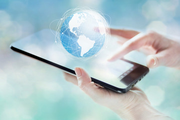 tablet in woman hand with globe