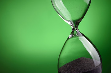 Close-up hourglass on green background