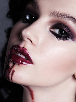 Closeup of bloody red lips young girl. Dark fashion beautiful br