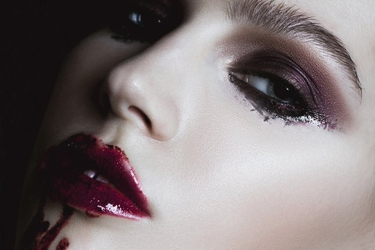 Closeup of bloody red lips young girl. Dark fashion beautiful br