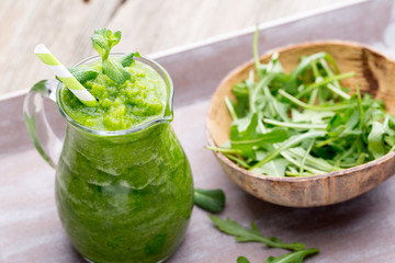 Rucola smoothie, on the grey  background.