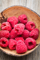 Frozen raspberries on wooden background.