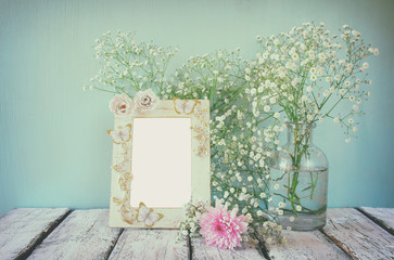 image of pink and white flowers and antique frame on wooden table. template, ready to put photography
